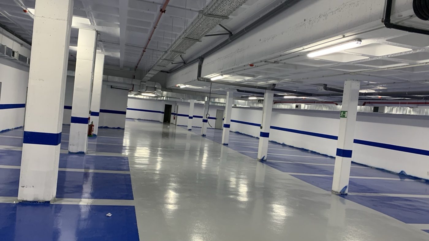Vista de un garaje con suelo epoxi gris y azul