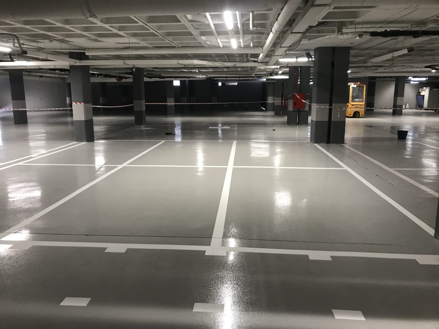 Garaje con pavimento epoxi gris y plazas señalizadas