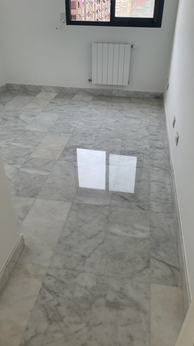 Suelo de mármol blanco y gris con reflejo de una ventana