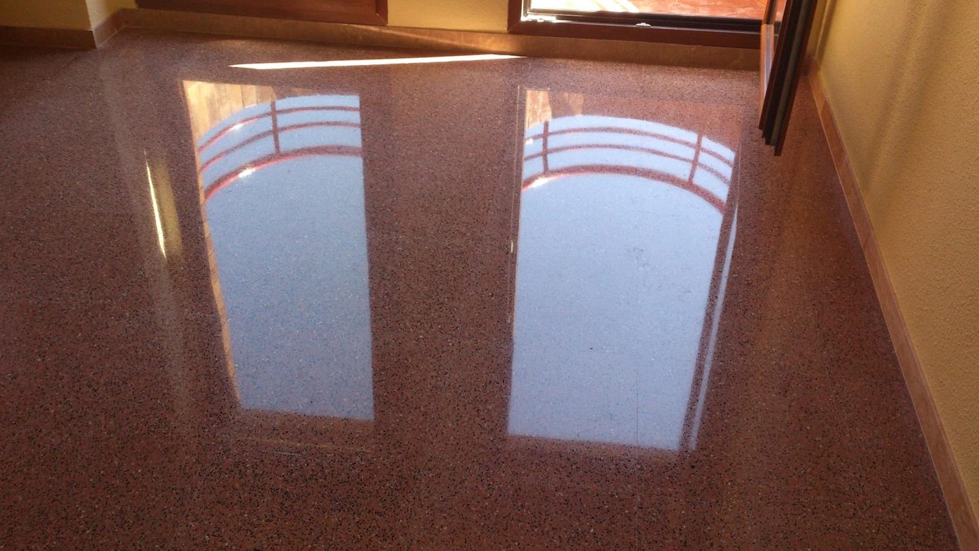 Reflejo de una ventana sobre terrazo de tono rojizo