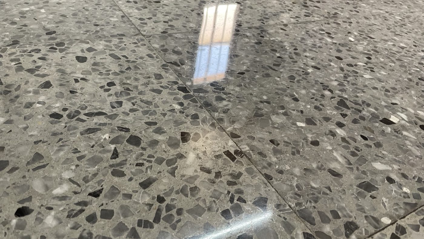 Detalle del brillo en un suelo de terrazo gris