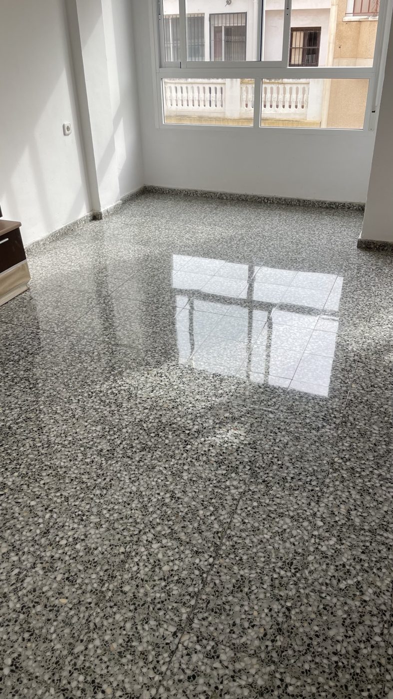 Suelo de terrazo gris con reflejo de la ventana