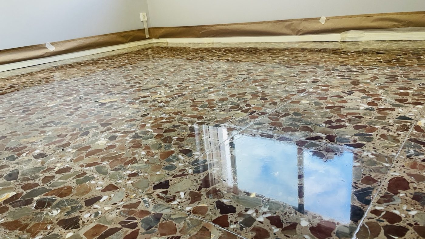 Terrazo con árido de distintos colores y reflejo de una ventana